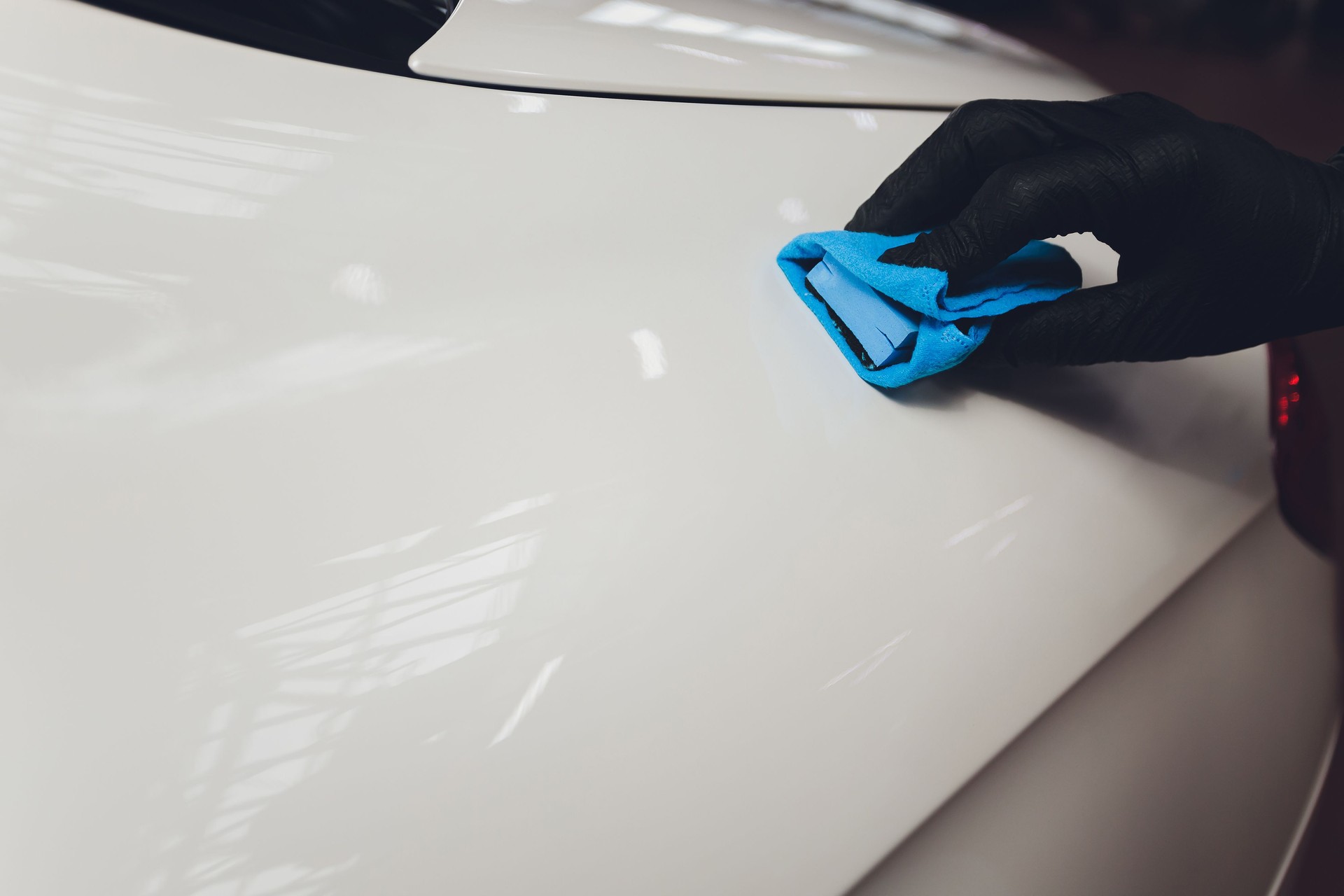 Auto Detaillierung - Der Mensch trägt Nano-Schutzbeschichtung auf das Auto. Selektiver Fokus.