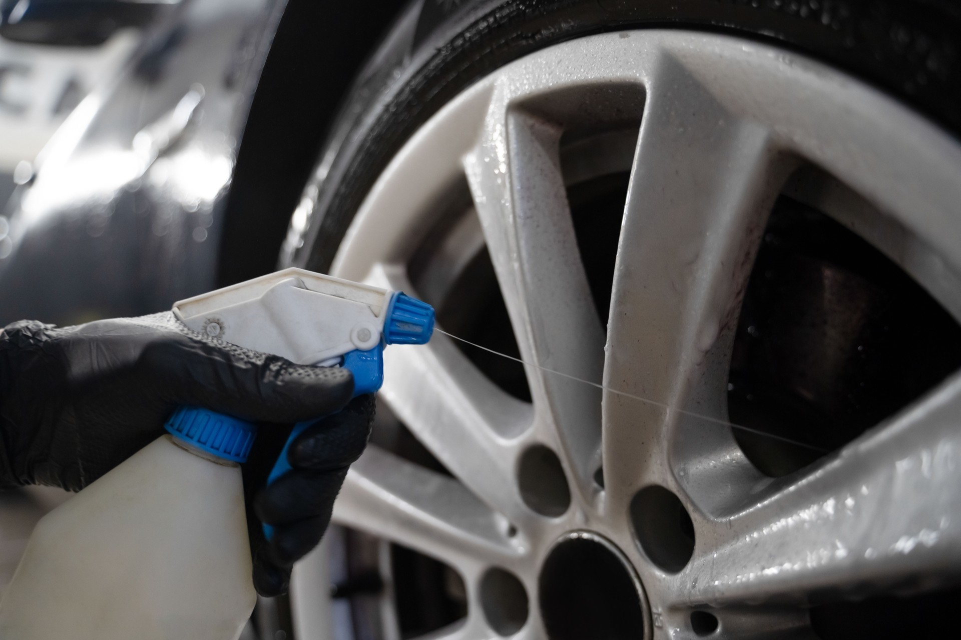 Auto Detailing Worker wendet Chemie auf Räder an. Professionelle Autoradwäsche