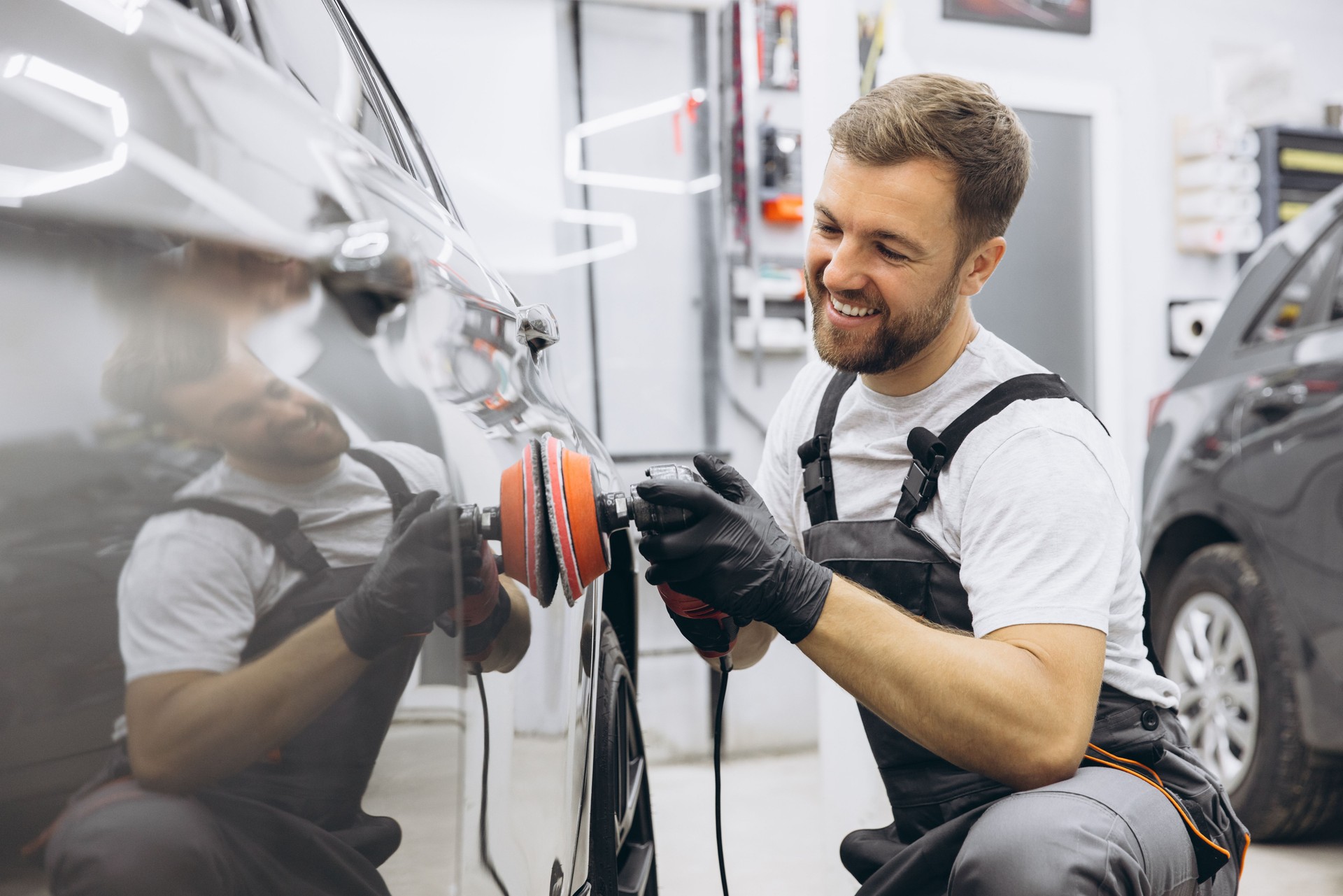 Professionelle Autoaufbereitung mit einem Autopolierer in einer Garage